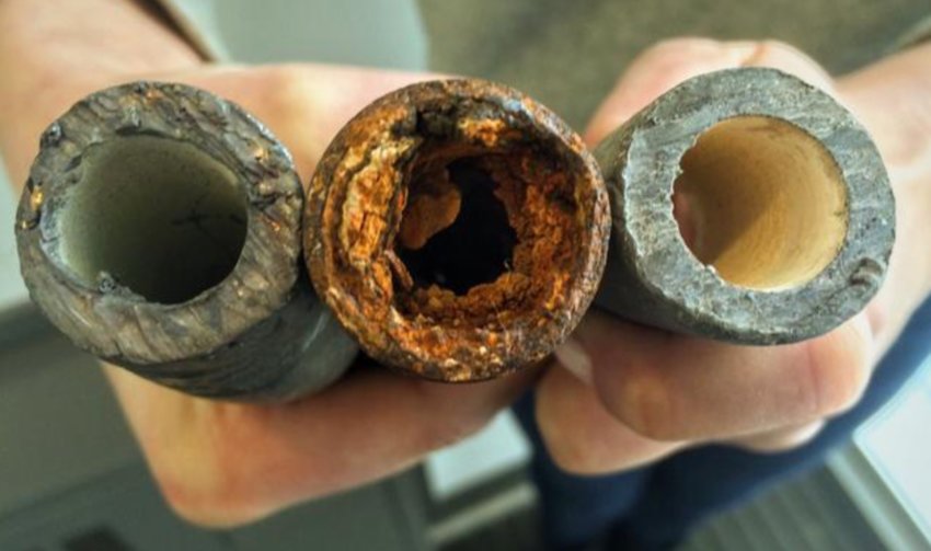 An individual holds a lead pipe, a steel pipe and a lead pipe treated with protective orthophosphate. The Environmental Protection Agency is only now requiring water systems to inventory their lead pipes decades after new ones were banned.