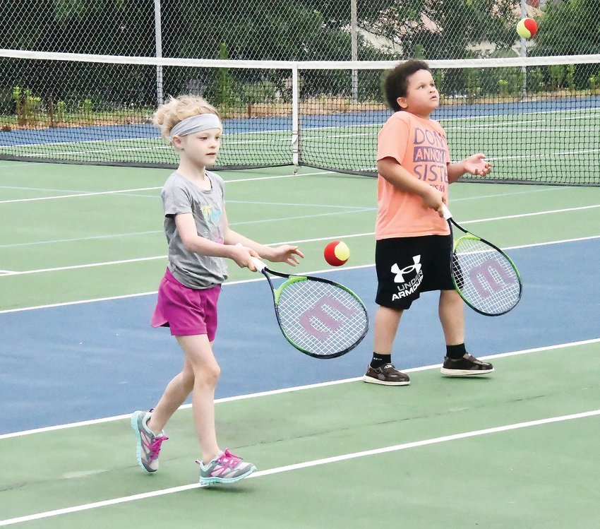 Alexa Moore (left) and Jaxon Woodson work on keeping the ball in the air during a drill at tennis lessons on Friday, June 24, at the Shelter One Courts inside Rothwell Park.