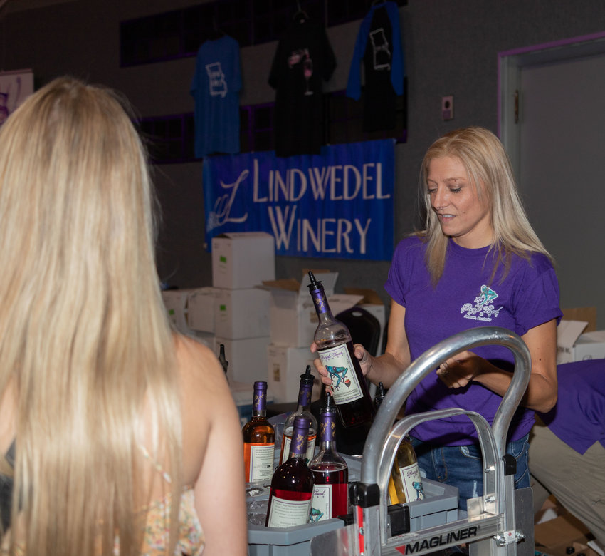 Amanda Linneman of Purple Toad Winery offers a gourmet sweet wine&mdash;chocolate strawberry&mdash;at Moberly Municipal Auditorium Saturday, the starting point for Safe Passage&rsquo;s annual Wine Stroll.