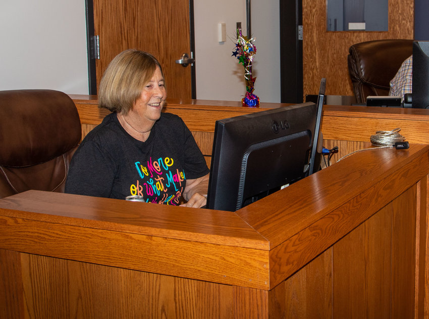 Ginger Tipton takes her seat in the county commissioner&rsquo;s office for the last time. Tipton retired in August after six years as commission secretary.