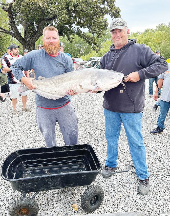 Kaleb McAdams (left) and Chris Baker show off the winning catfish from the Dalton Bottoms High Stakes Tournament on Sunday, Aug. 28, in the Chariton County town of Dalton. The catfish weighed a whopping 55.6 pounds, almost 20 more than second place.