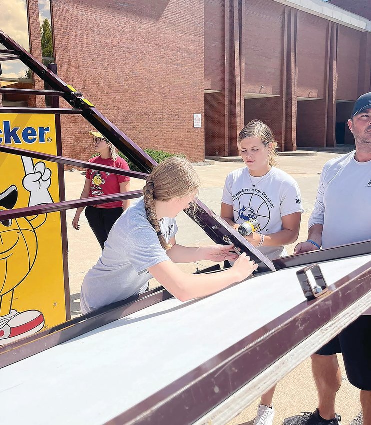 Moberly High School girls&rsquo; basketball players Zoey Hannam (left) and Kennedy Messer help assemble goals for the upcoming Gus Macker 3-on-3 tournament set for this weekend on Williams Street in downtown Moberly.