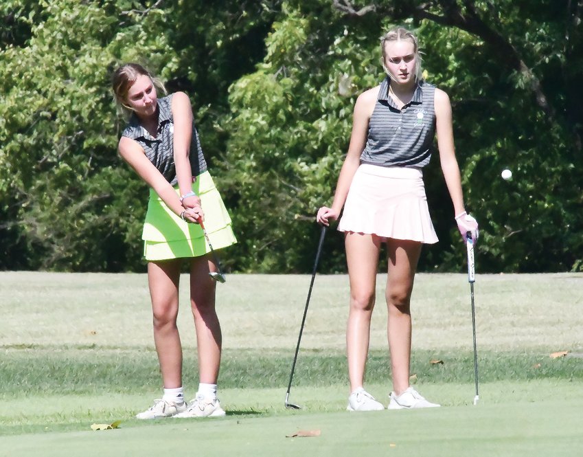 Cairo girls&rsquo; golfer Kennedy Kearns (left) chips the ball onto the green while teammate Macie Harman watches during Tuesday&rsquo;s Harrisburg Scramble at L.A. Nickell Golf Course in Columbia. Scramble tournaments are becoming increasingly popular on both high school boys&rsquo; and girls&rsquo; golf schedules.