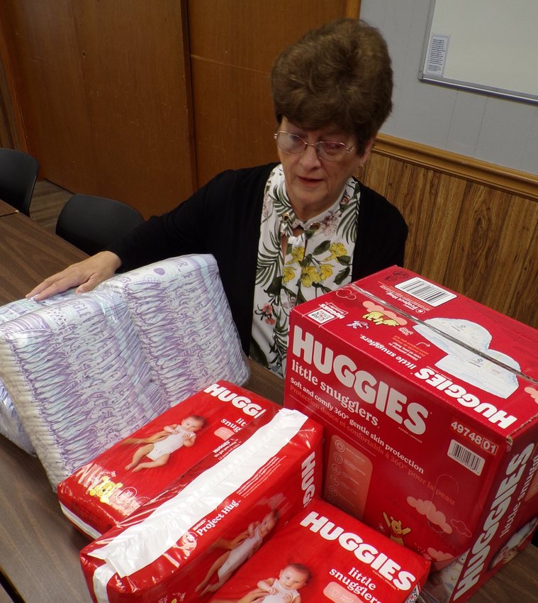 Linda Fritz shows the diapers that North East Community Action Corporation will give away to qualifying families.
