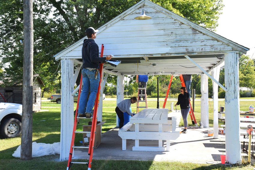 Employees of Chariton Valley and Macon Electric Cooperatives paint a shelter in a park in Jacksonville.