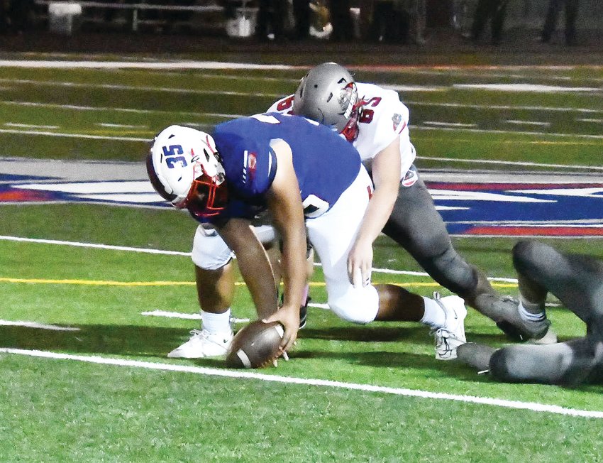 Moberly's Javaughn Briscoe (35) picks up a fumble early in the third quarter. Briscoe was part of a Spartan defense that forced three fumbles and had four pass break-ups in a 28-14 victory over Mexico on Friday at Dr. Larry K. Noel Spartan Stadium in Moberly.