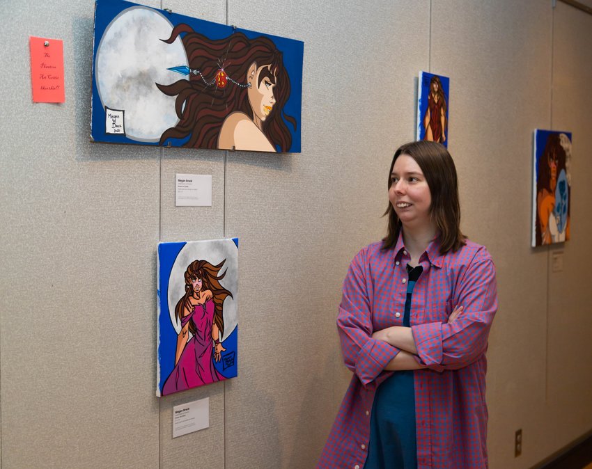 Werewolf enthusiast Megan Brock explains her artwork during an artist&rsquo;s reception at Jorgenson Fine Arts Gallery at Moberly Area Community College. Brock's drawings and paintings will be on display through October.