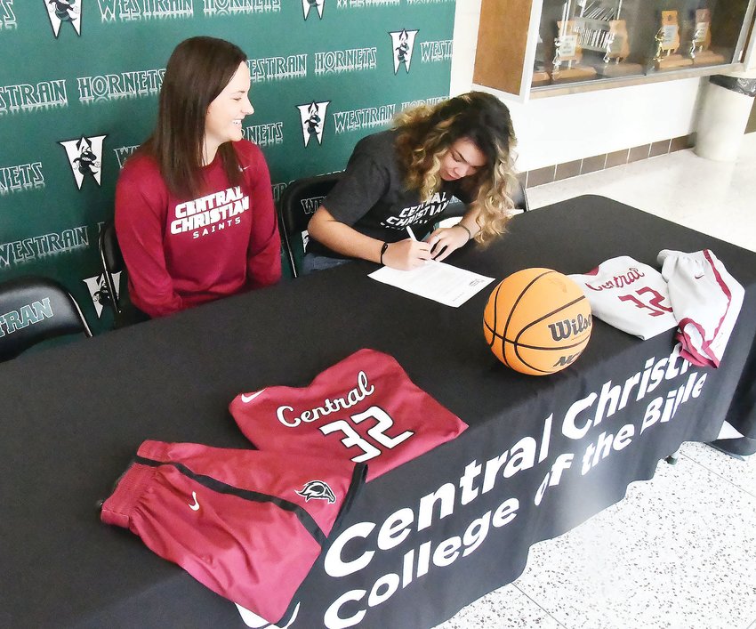 Central Christian College of The Bible head women's basketball coach and athletic director Kori Zarzutzki watches as Westran's Maci Crutchfield signs her intent letter to join the Saints.