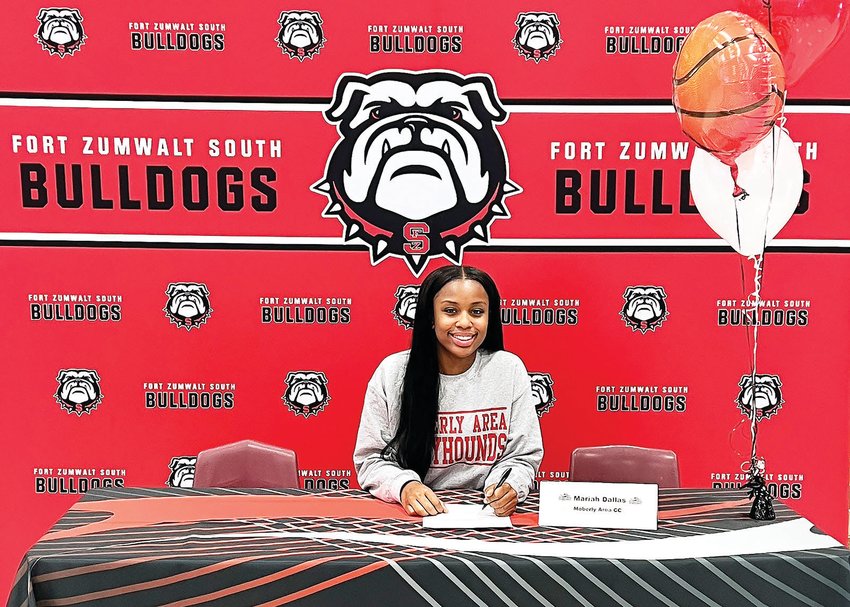 Mariah Dallas is shown at her signing ceremony, putting pen to paper signing with the Moberly Area Community College women's basketball team.