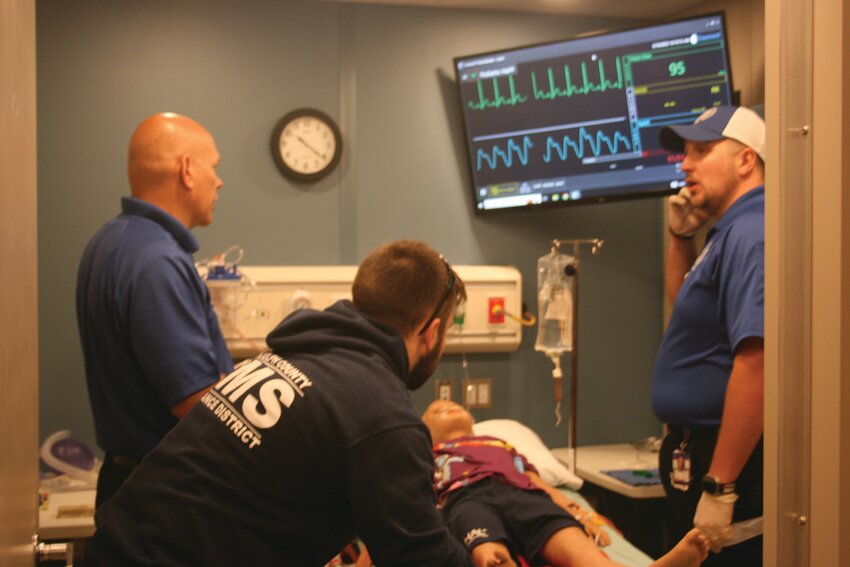 Pediatric Hal was in hypovolemic shock but after receiving care from Randolph County ambulance personnel his condition was much improved. Taking part in the simulation are, from left, Jason Cook, paramedic; Blake VanConett, EMT; and Joe Roberts, EMT. Photo by Janet Morales