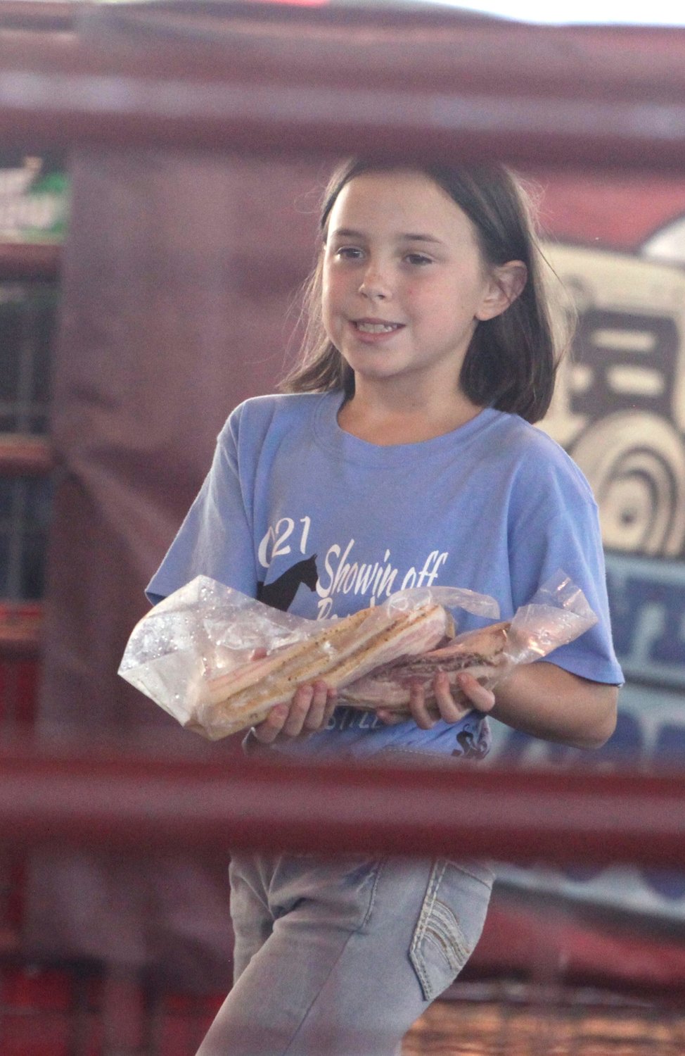 Brette Drew shows off her Grand Champion Bacon before interested buyers at the  2021 Randolph County 4-H/FFA Fair Blue Ribbon Auction held July 16 at the Riley Pavilion in Moberly's Rothwell Park.