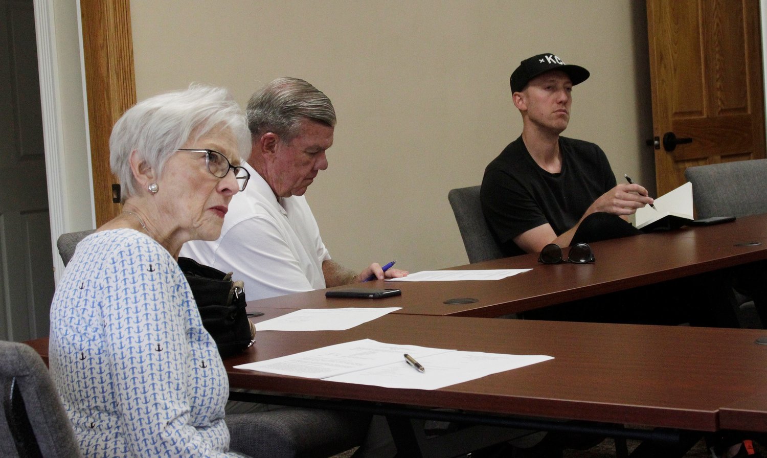 Moberly Historic Preservation Committee members Sara Fleming, left, and Adam Flock, right, listen to a presentation made while Doug Sharp takes notes during a July 13 public business meeting held at the Municipal Building in downtown Moberly.