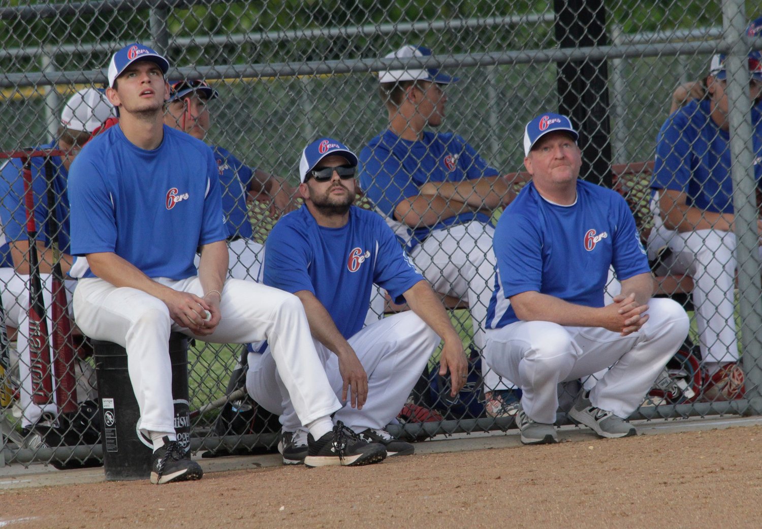 A fly ball catches the attention of NEMO Post 6 Sixers coaches Jackson Truesdell, Drew Hunt and Kevin Pipes as they sit outside of the team's dugout during a home baseball game played earlier this 2021 season.
