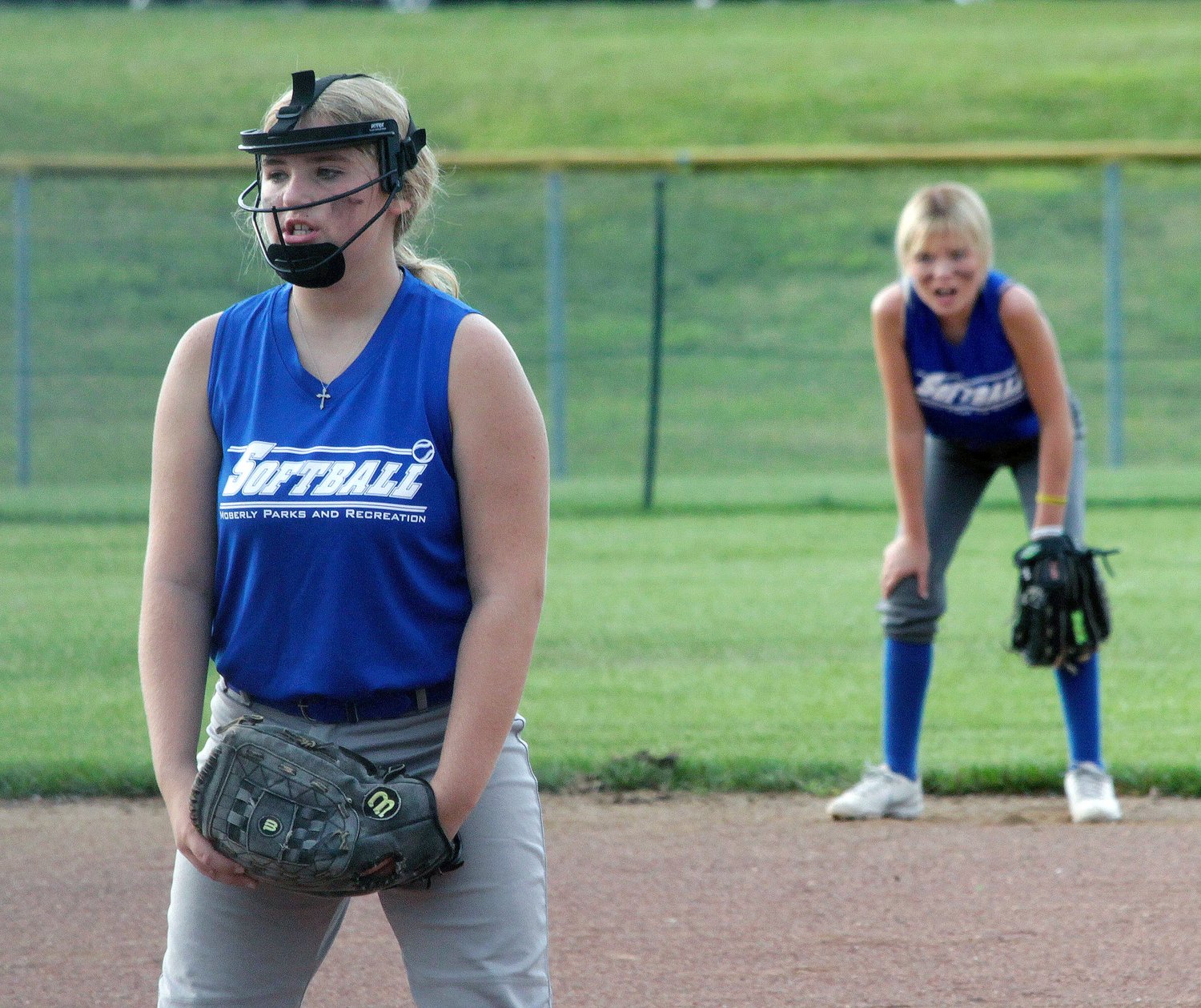 Moberly No. 2 age 12U girls softball team first baseman Kamryn Fallaw and right fielder Jerzee Bruce prepare to field a potential batted softball Wednesday during a Moberly Parks &amp; Recreation Department league game played at the Howard Hils Athletic Complex. Moberly No. 2 girls edged Centralia 8-6 in three innings.