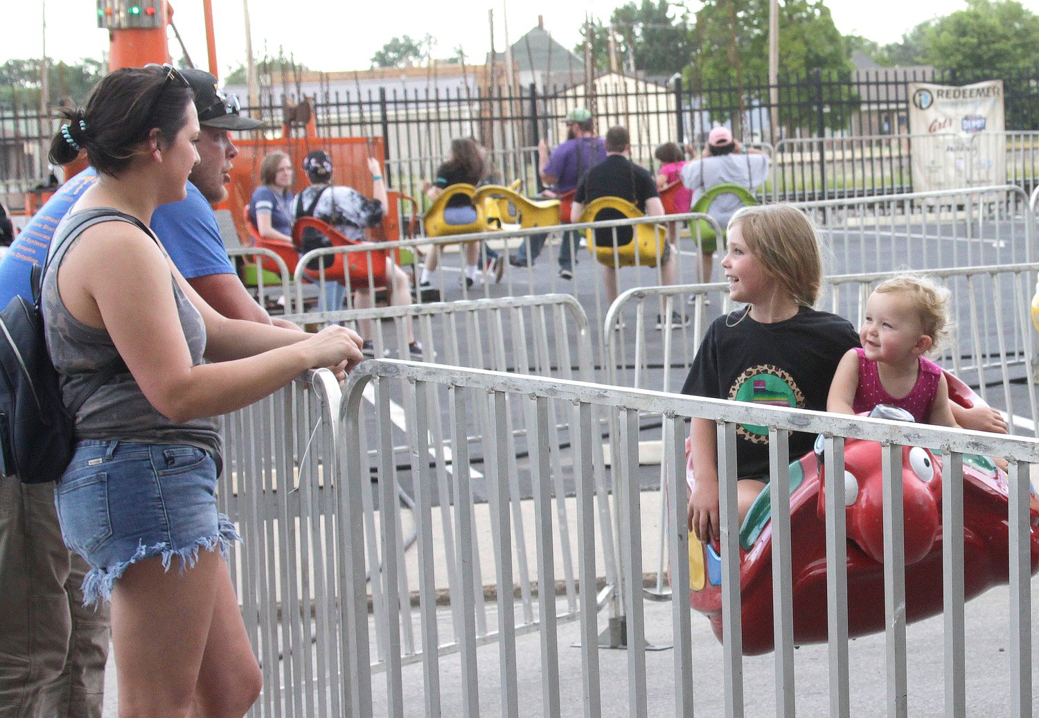 Five year-old Quinn Day holds onto her 2-year old sister Brenna as they enjoy their children's amusement ride going past their parents, Jake Day and Kate Lewis, Wednesday evening at the Railroad Days festival in downtown Moberly. The four-day event offers a variety of evening activity and culminates Saturday, June 19.
