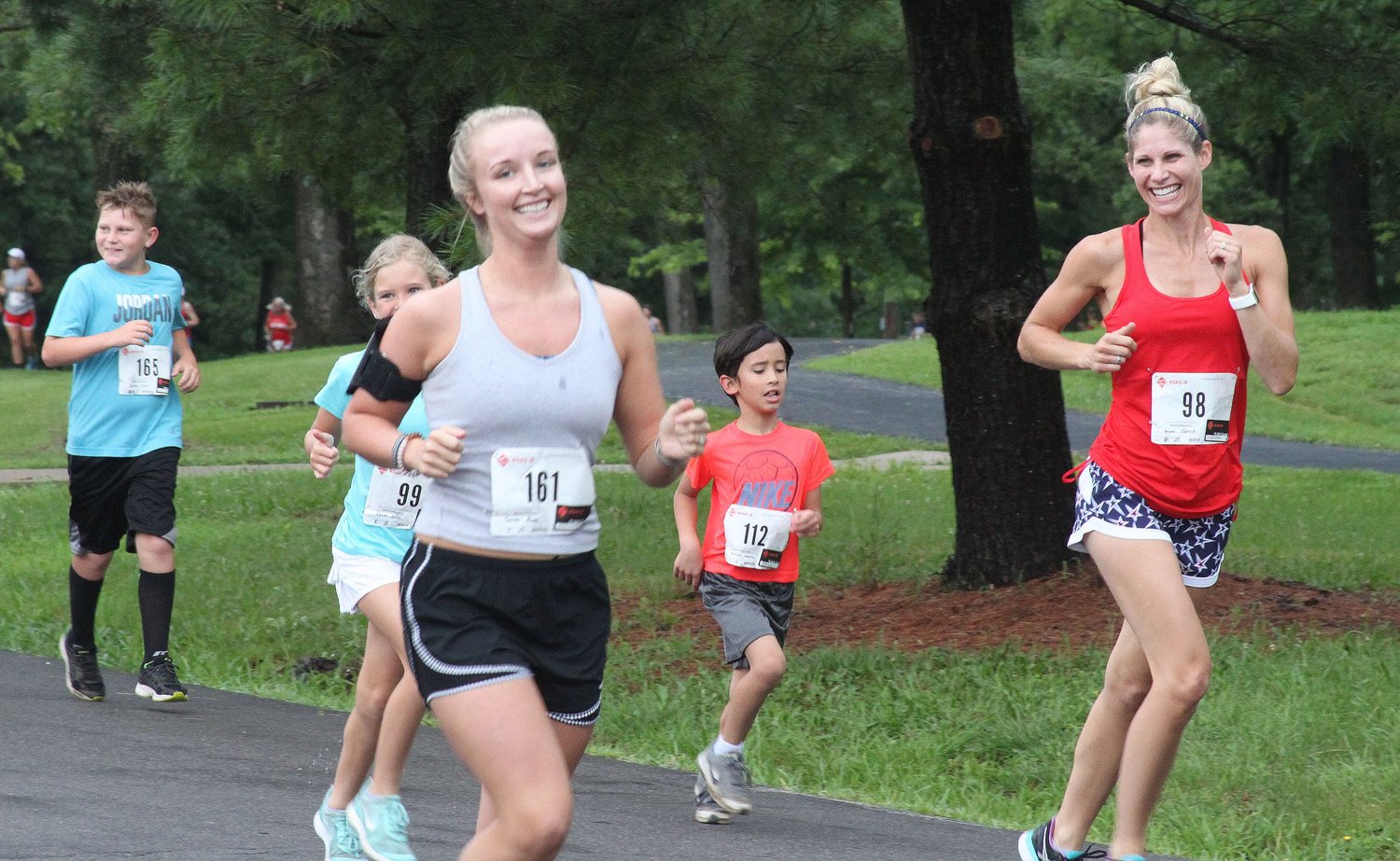 A pair of female runners join other participants of the 2019 Moberly Independence Day 5k Run/Walk fundraiser through Rothwell Park  for the high school's cross country program.The Sunday morning July 4 event will be the 29th time this 5k has taken place as the COVID-pandemic forced last year's event to cancel.