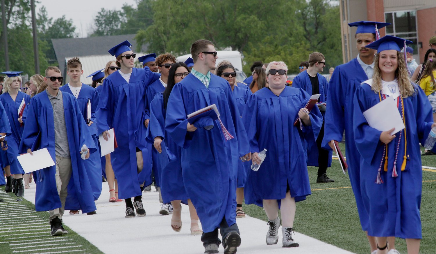 Moberly High School Class of 2021 graduates leave Dr. Larry K. Noel Spartan Stadium at the end of the 53rd Commencement ceremony while the band plays the school's fight song.