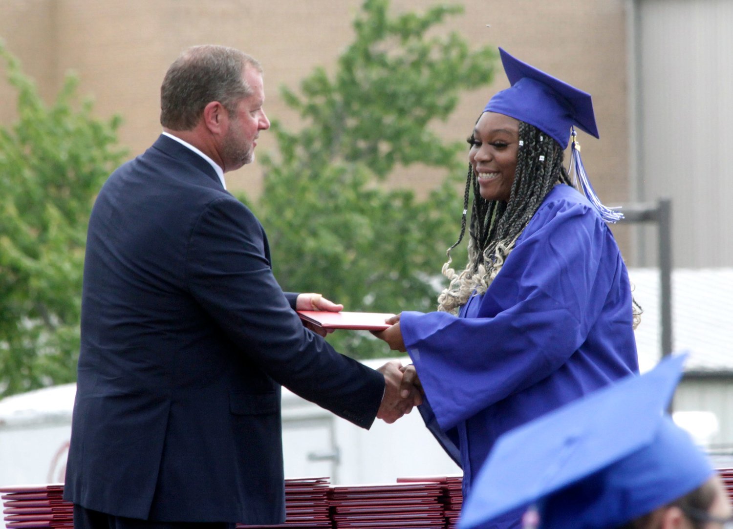 Moberly senior Whitney Sharé Jones receives her diploma from Moberly Board of Education President Bobby Riley.