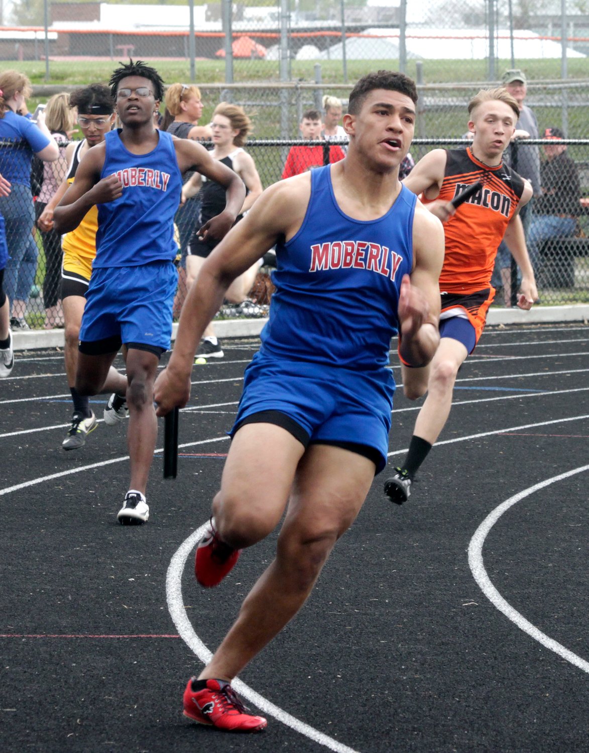 Upon receiving the baton from Mar'sean Winn, left, Moberly senior Jacksyn Miller grips the stick as he jets off running the third leg of the boys 4x200m relay race Tuesday during the Gerald Mansfield Track Invitational held at Macon. Miller and his Spartans comrades placed second in this event, and the same group won the 100m relay.