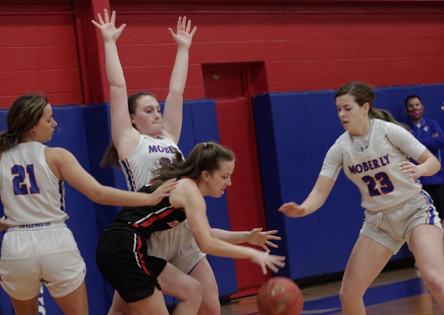 Moberly High School junior Alaina Link raises her arms as she stops the dribble penetration of Hannibal senior Ellie Locke during Saturday afternoon's Class 5 District 15 Tournament opening game. Moving in to assist Link are sophomore Kennedy Messer (#23) and senior Sam Calvert (#21). The Moberly trio helped the fourth-seed Lady Spartans knock off Hannibal 59-39 at home to advance to Monday's 6 p.m. semifinal where they battle top-seed Mexico at the Bulldogs home court.