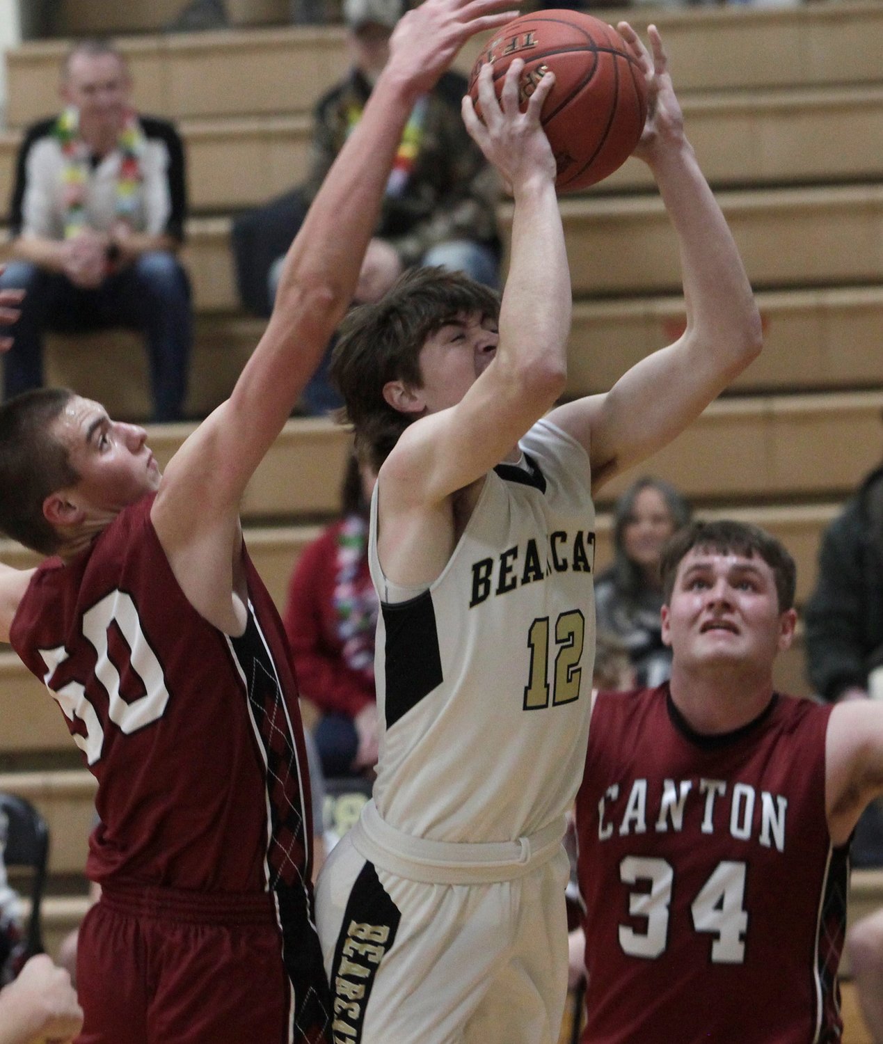 Justin Gittemeier (#12), a 6'1 Cairo junior, attempts to put up a short jumper Wednesday while Canton 6'8 sophomore Kyle Frazier reaches from behind to try and block his shot. Cairo defeated Canton 60-42 in a boys semifinal game of the Class 2 District 6 tournament.