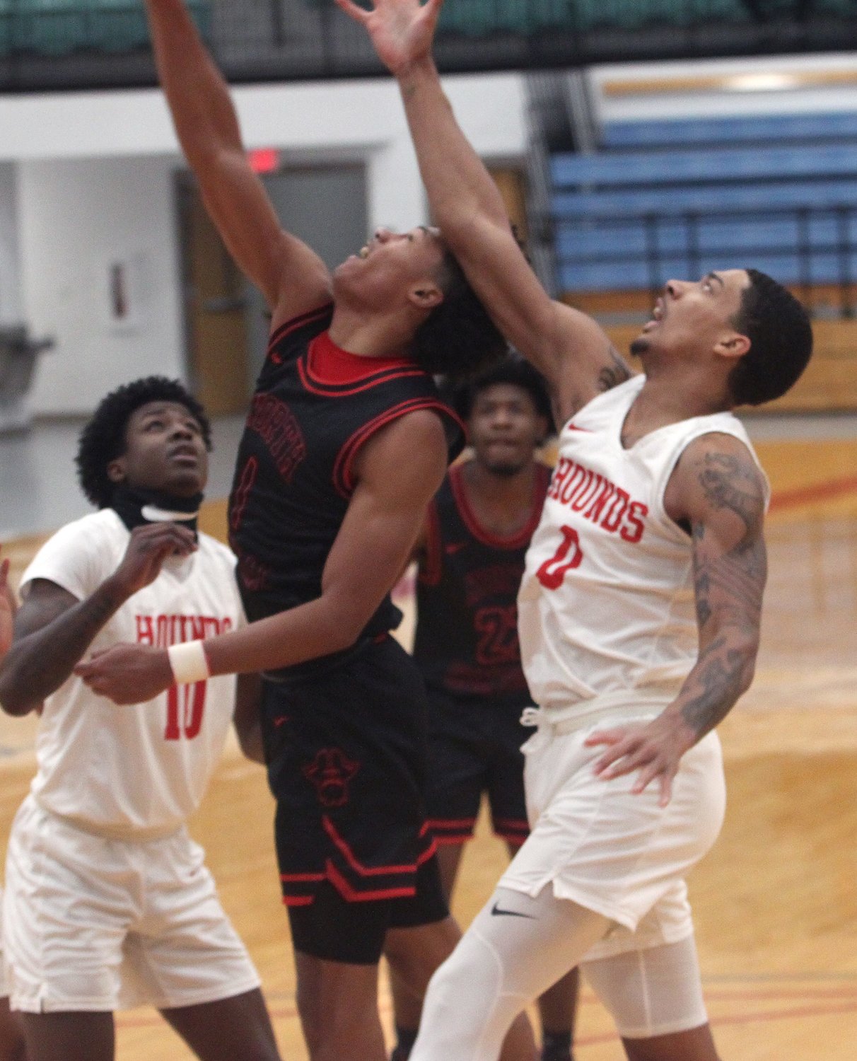 Aarron Burt of the Moberly Greyhounds (#0) reaches up against North Central Missouri College's  Kolten Griffin as the two contend for a rebound Tuesday while Burt's teammate Cortez Mosely looks for the same opportunity. MACC men held off North Central winning 110-109 at home in overtime.