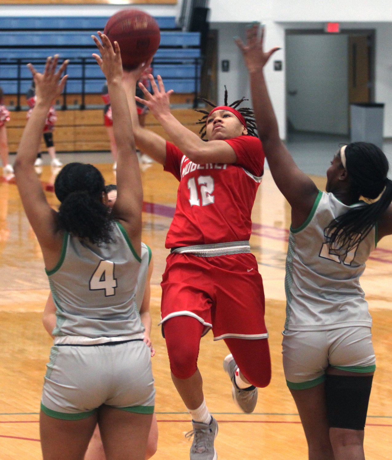 Moberly Area Community College sophomore Bi'Anna Pettis splits the seams of Spoon River College's Jai'Renee McCoy (#4) and T'Alla Brown as she attacks the rim and draws a foul Saturday. Pettis made three free throws to help the Lady Greyhounds earn a104-57 home victory at the Orscheln Industries Classic.