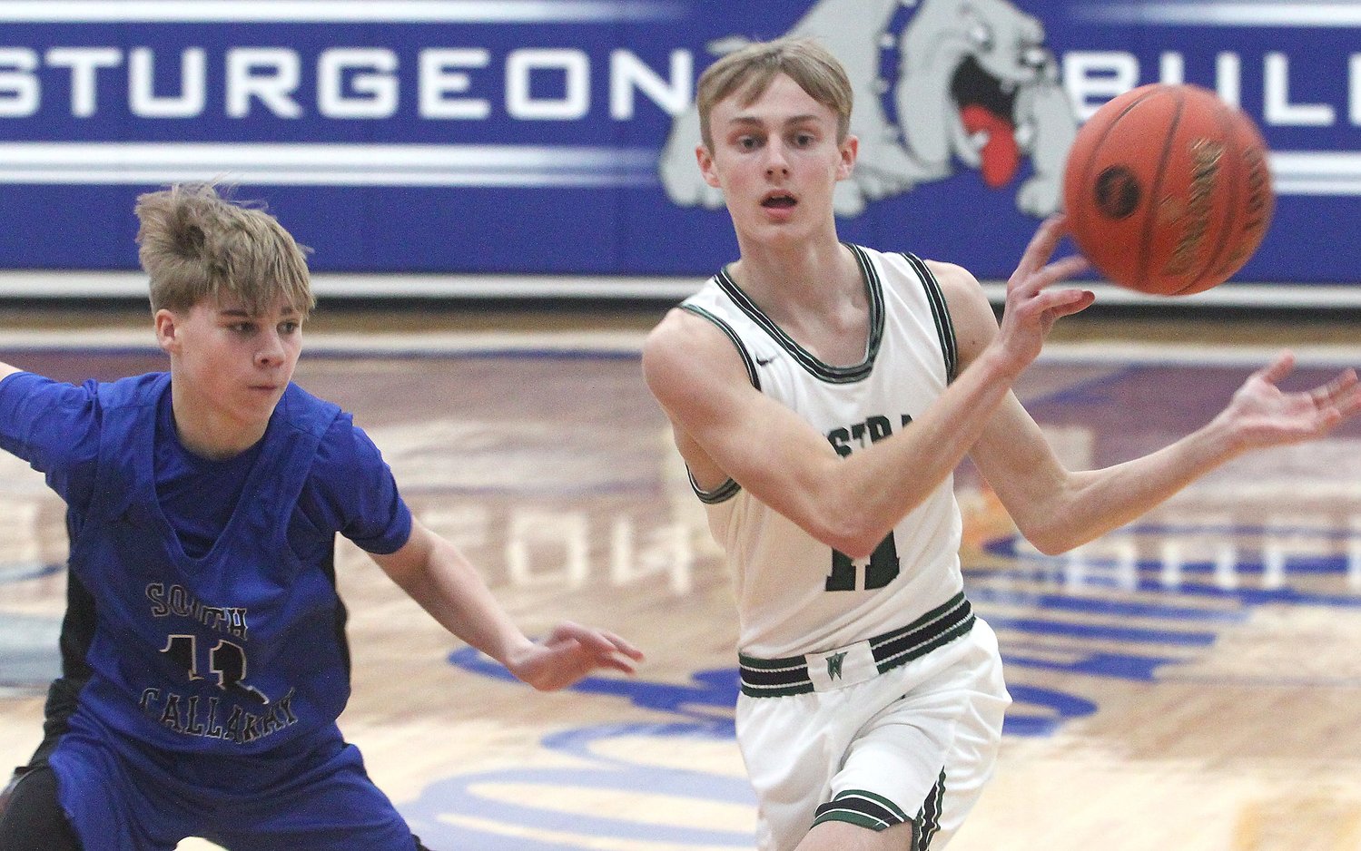 Westran High School junior Trey Marble makes a 'no-look' pass while being defended by South Callaway's Tayber Gray during Thursday's semifinal game of the Sturgeon Invitational. Marble supplied three 3-pointers and 11 points to help the top-seed Hornets win 67-49.