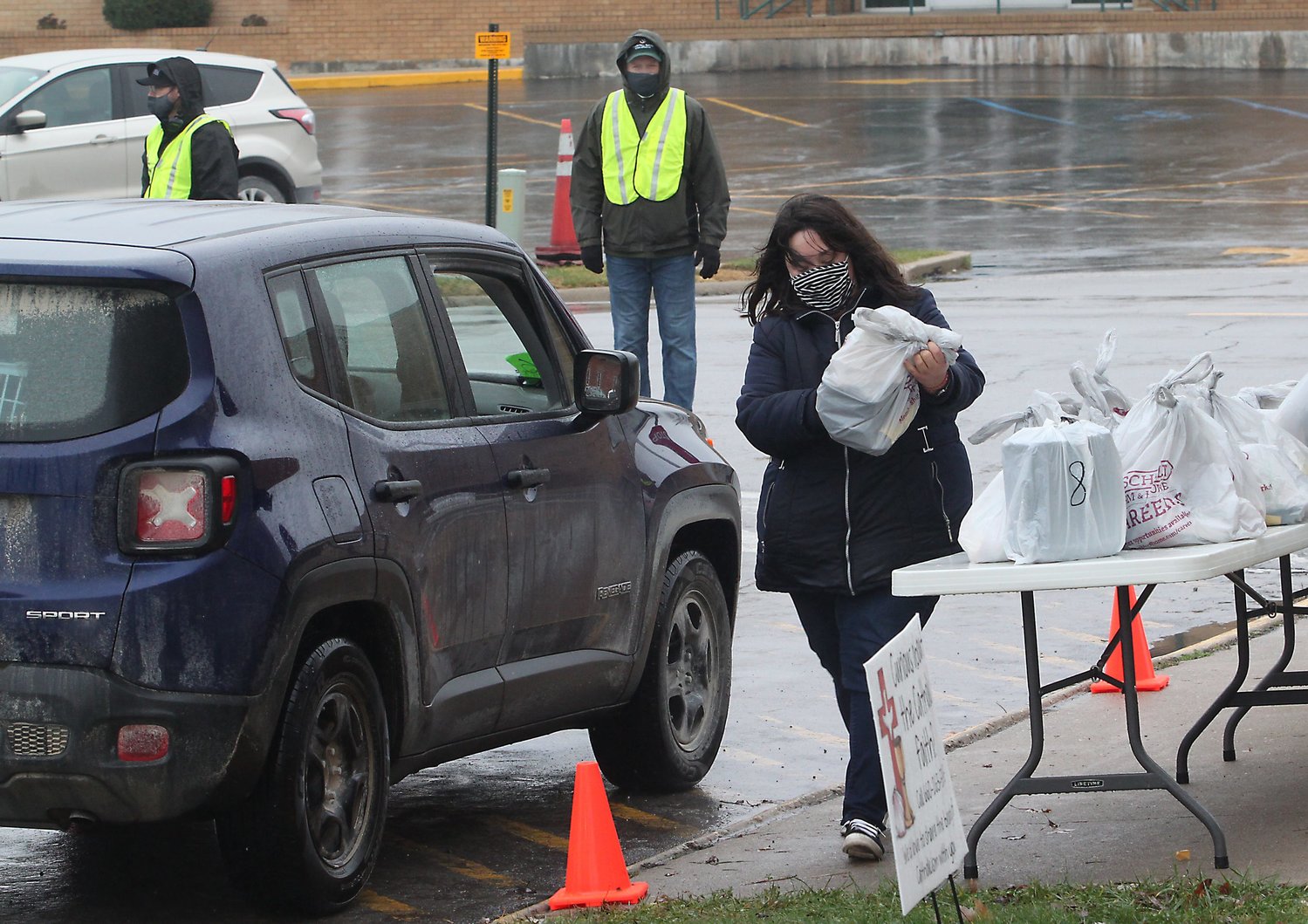 Crystal Wright prepares to place Thanksgiving meals into a vehicle Wednesday during the 16th annual Moberly Community Goodwill Thanksgiving Dinner. Meals were distributed in a drive-thru or pedestrian pick-up at Saint Pius X Catholic Church instead of the sit-down meal at Zion Lutheran Church in Moberly due to COVID-19 restrictions.