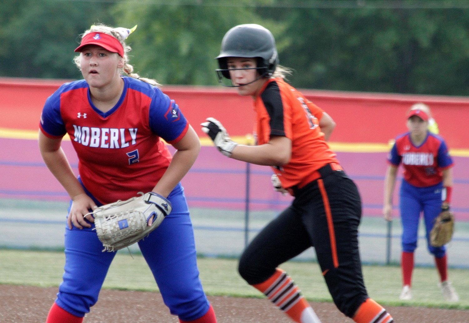 Moberly sophomore starting first baseman Taylor Martin readies herself into defensive position while Kirksville's Mallory Lymer dashes toward second base on a batted ball during the second inning of Thursday's softball game at Moberly. The Lady Spartans lost 6-3.