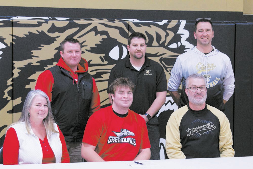 Cairo senior Jack Prewett, center, signed a letter of intent to play baseball for Moberly Area Community College during the program’s inaugural season during the 2022-23 school year. Prewett is surrounded by his parents, Sara and Mike.  Standing, left to right, are MACC baseball coach Chris Fletcher, Cairo baseball coach Morgan Matthews and Cairo boys basketball coach Nic Zenker.