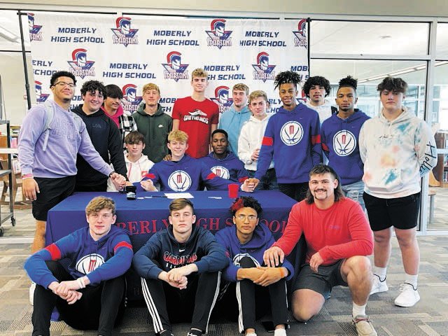 Cael Head, center, poses for a photo with the Moberly baseball team after signing his letter of intent to play baseball at Moberly Area Community College.