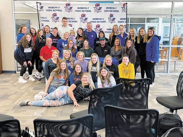 Madyson Klostermann, center, is surrounded by her team and friends after signing her letter.