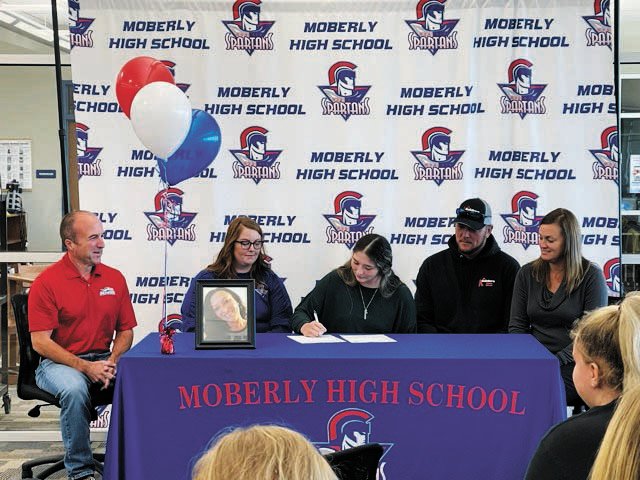 She is surrounded by her dad Kevin Klosterman and friend Ruchelle Jacobi,  Moberly Softball Assistant Coach Ashley Crutchfield and Head MACC Softball Head Coach Matt Bauer.