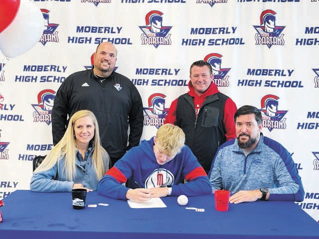 Cael Head, center, signs his letter of intent. He is surrounded by his parents, Leslie and Scott, Standing are Moberly Athletic Director Curtis Walk and MACC Head Baseball Coach Chris Fletcher.