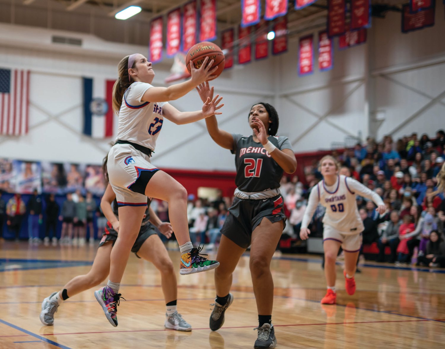 Moberly’s Kennedy Messer glides in for a layup in front of Mexico’s Capri’ona Fountain in last Thursday’s conference contest. Messer had 10 points in the 67-45 win at home. (John Wright Photography)