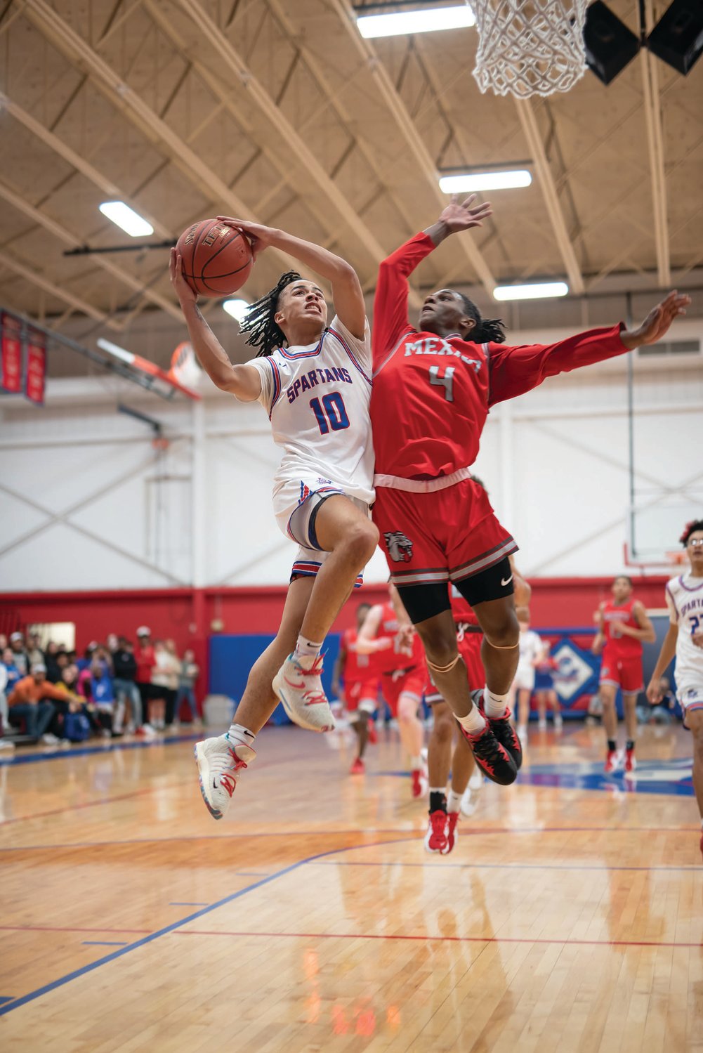 Moberly senior Jaisten Payne (10) has a layup contested by Mexico’s Jordan Shelton in last Thursday’s contest. Payne had a game-high 29 points in the 65-48 loss to the undefeated Bulldogs. (John Wright Photography)