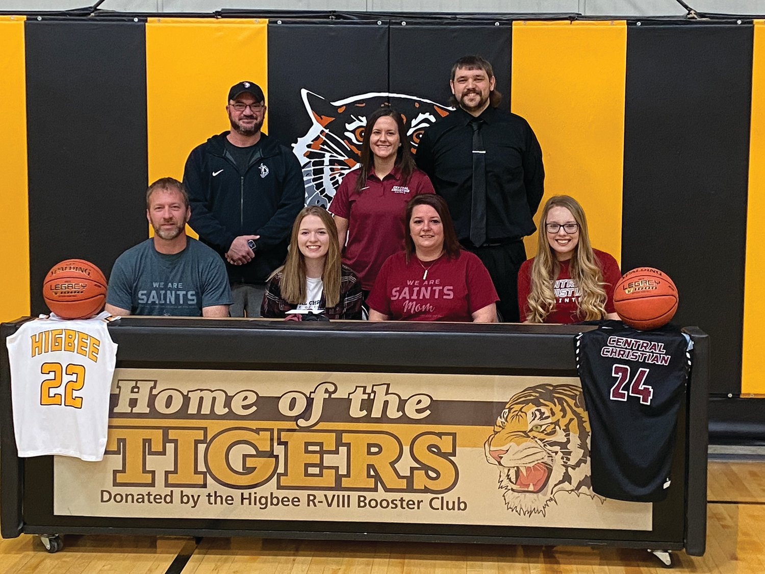 Higbee senior Macey Whisenand, front row second from left, signed a letter of intent to play basketball at Central Christian College of the Bible in Moberly on Feb. 11. Also pictured seated with Whisenand are her parents, Jonathan and Brandy Whisenand and her sister, Alexis. Back row, from left, CCCB assistant coach Allen Maltsberger, CCCB head coach Kori Zarzutzki and Higbee head coach Tanner Burton.