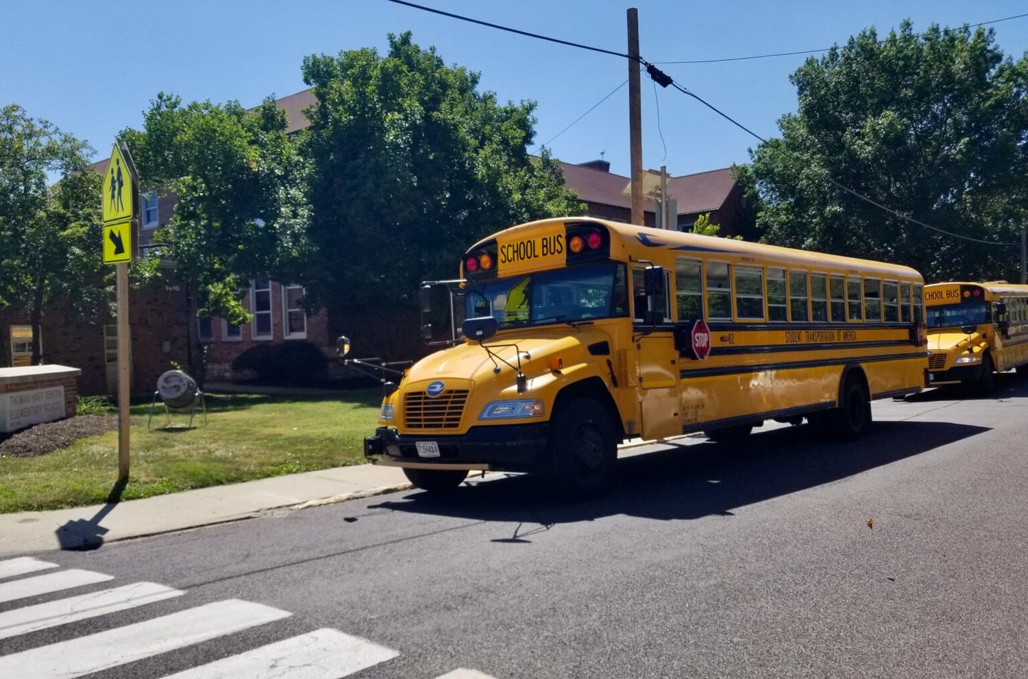 School buses wait outside Thomas Hart Benton Elementary School in Columbia last week to take students home from the first day of classes.