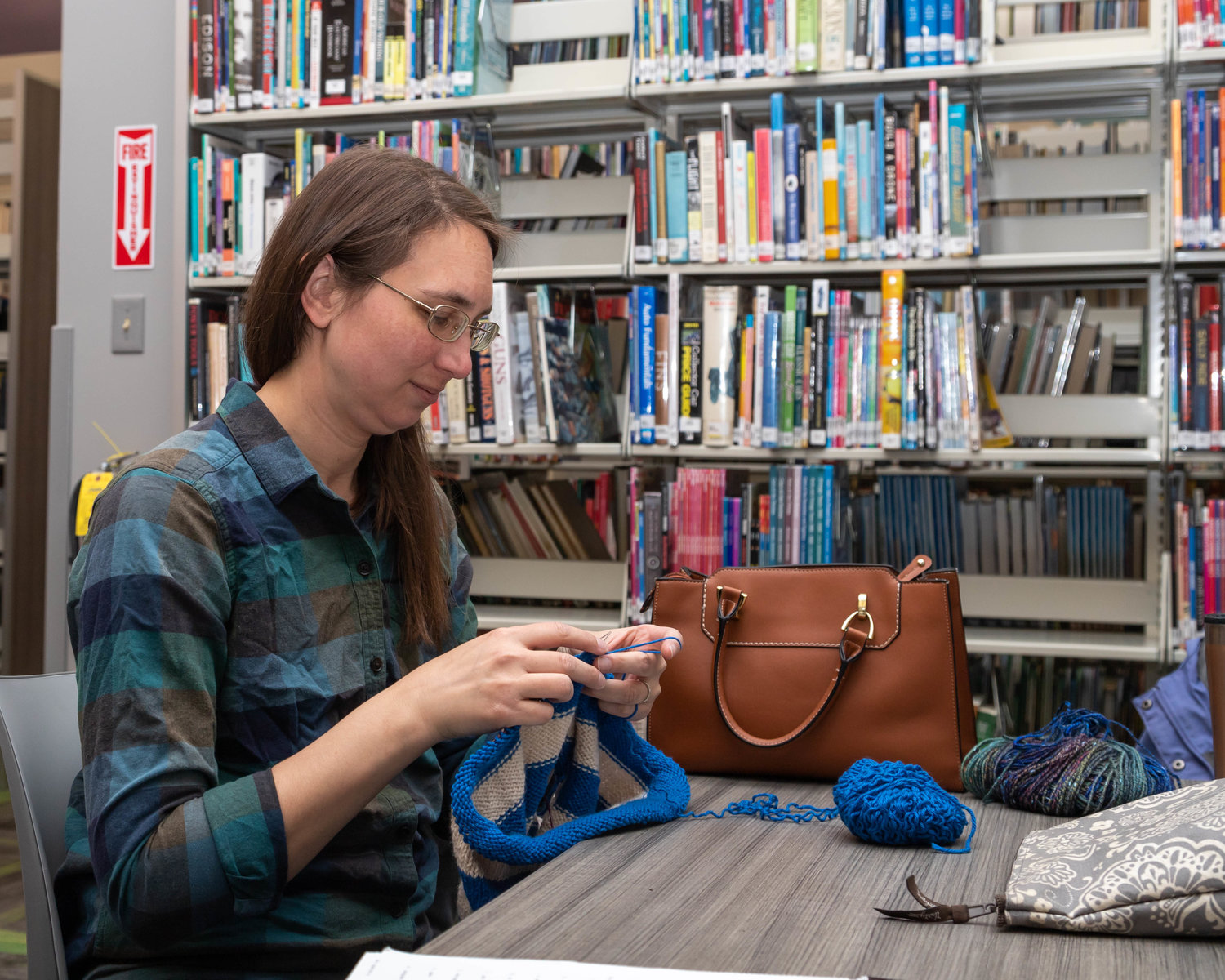 Emily Stoldt knits a sweater for her daughter at the Little Dixie Regional Library in Moberly.