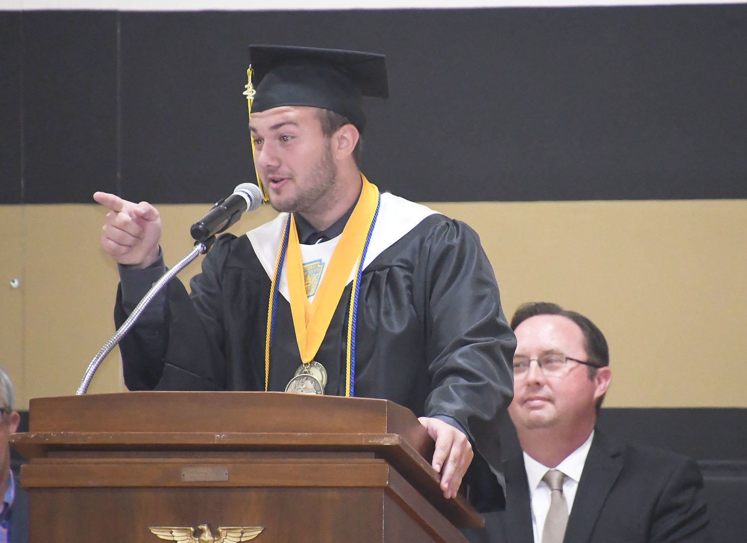 Class of 2022 graduate and co-valedictorian Trace Ackley points at a classmate during his speech.