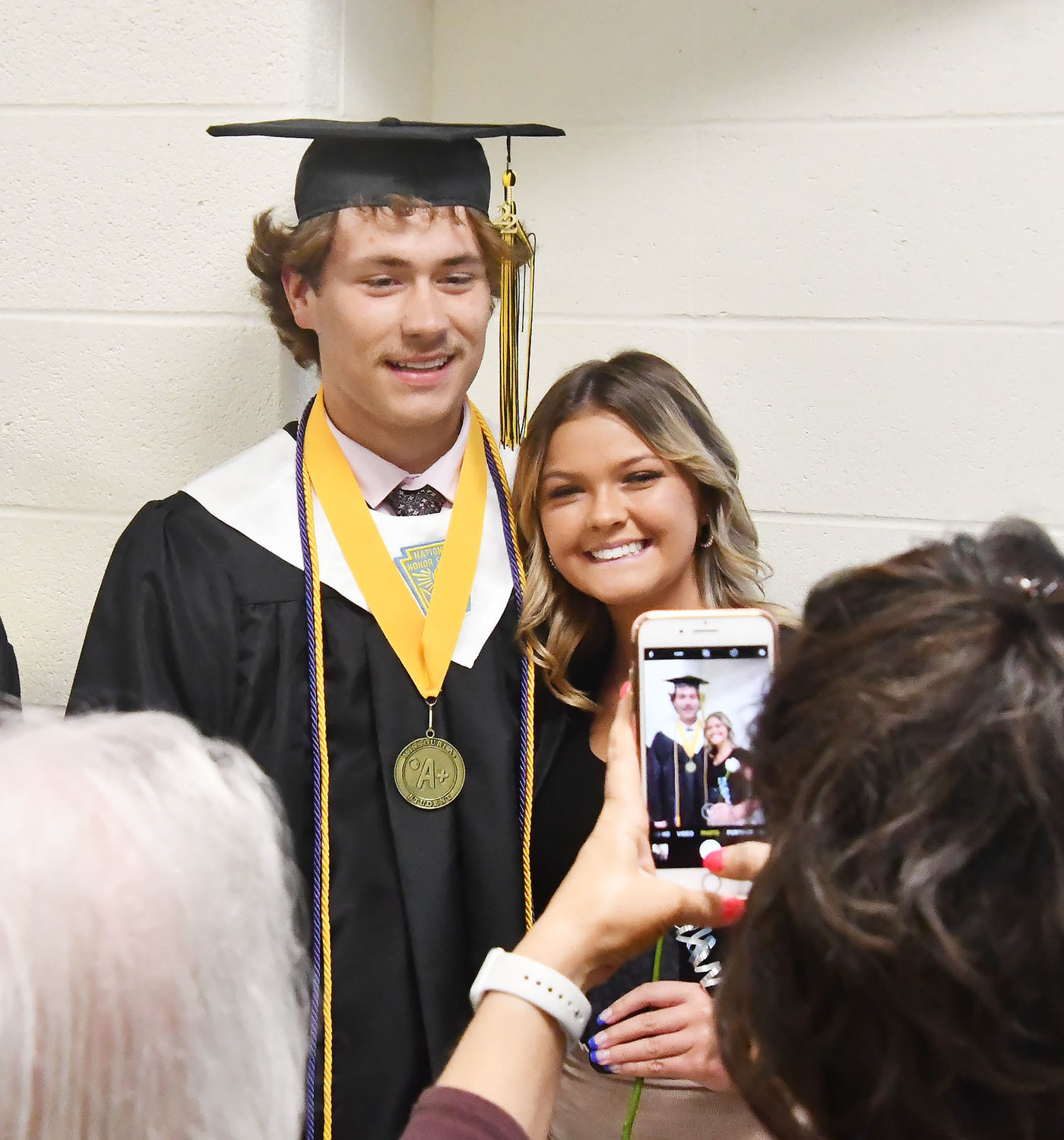 Class of 2022 graduate Austin Wright takes a cellphone photo after Sunday's commencement exercises. Wright presented the opening prayer during the event.