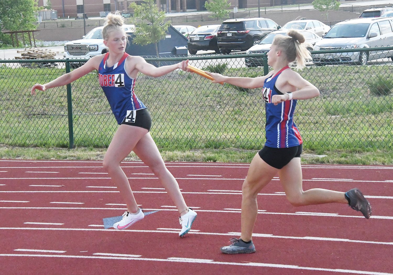 Moberly's Bryleigh Knox accepts the baton from teammate Anna Rivera during the running of the 4x400-meter relay at the Class 4 District 4 meet in Wentzville on May 14.