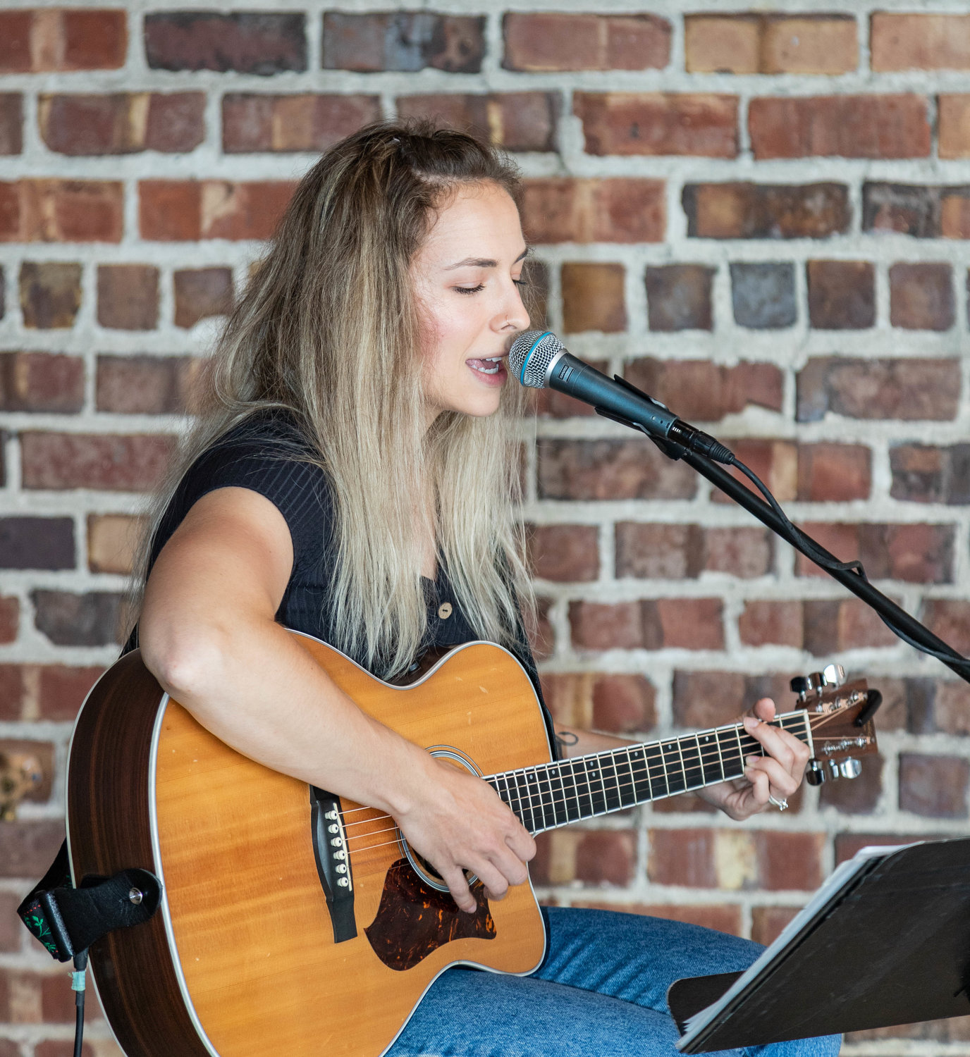 Aly Shipley accompanies herself on acoustic guitar as she sings classic pop and folk songs during June’s Street Food Throwdown at the Fennel.