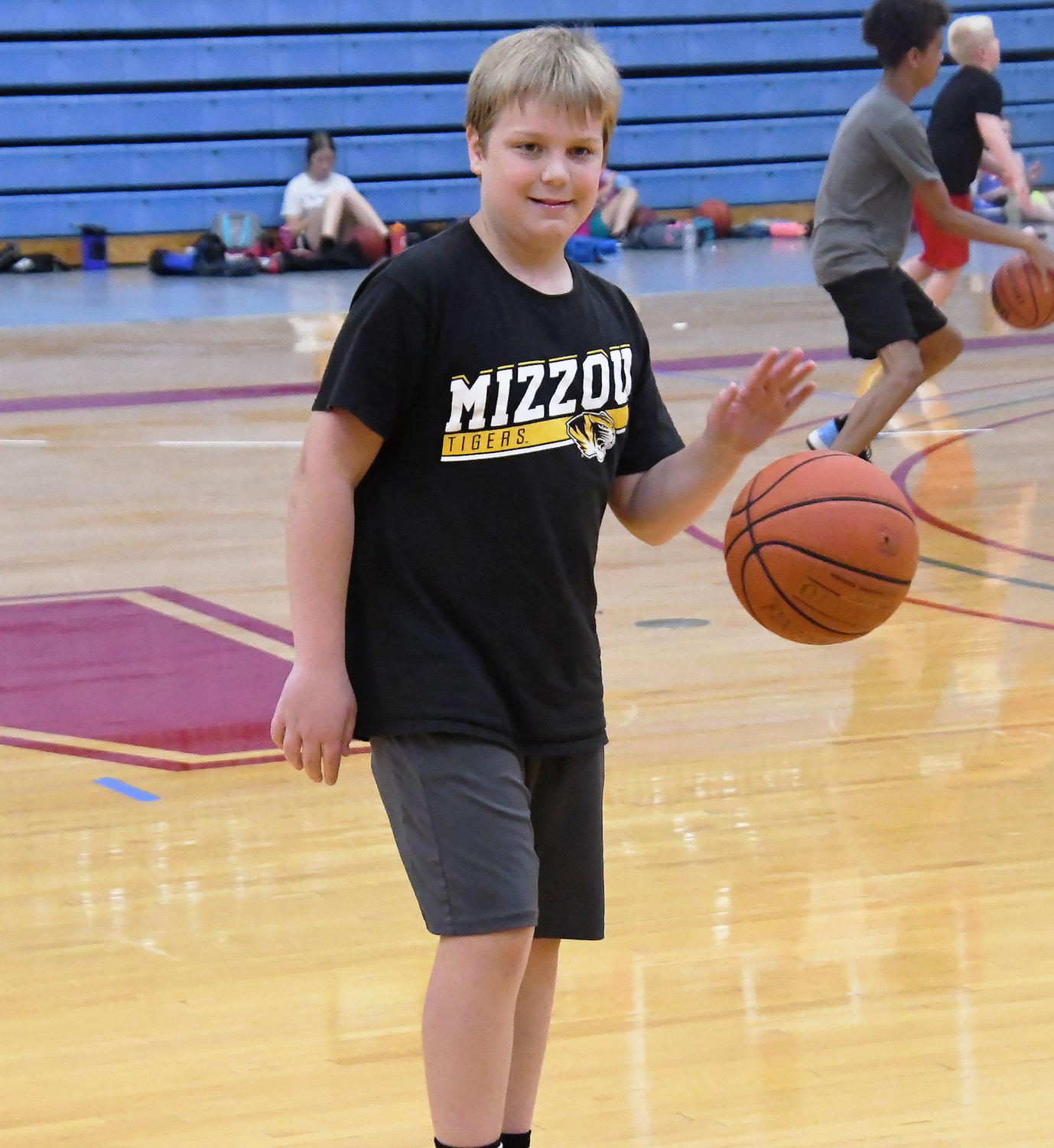 Brennen Douglass, in the University of Missouri T-shirt, smiles and dribbles at the same time.