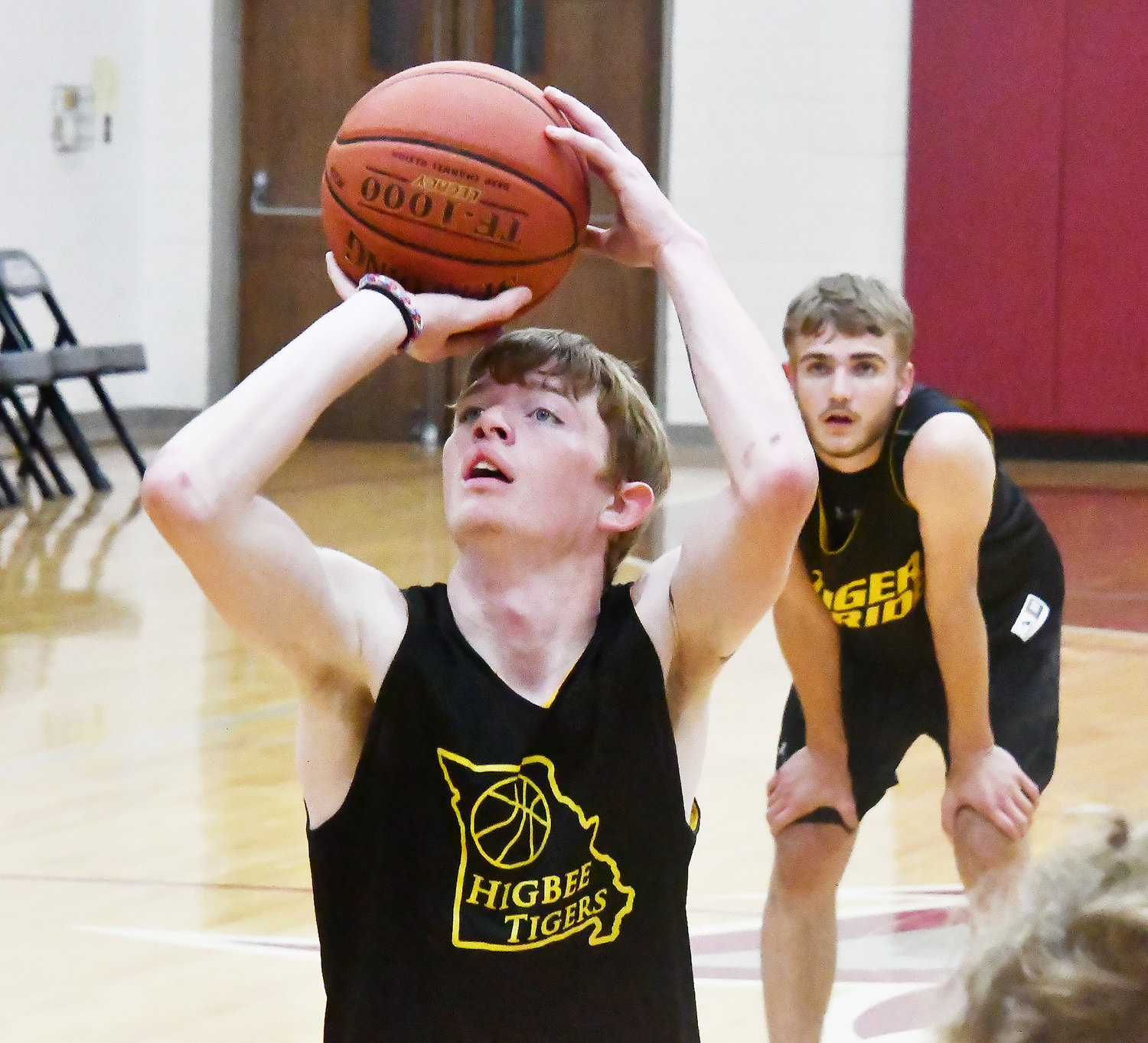 Higbee's Chad Crawford shoots a free throw while teammate Chevy Grimsley looks on.