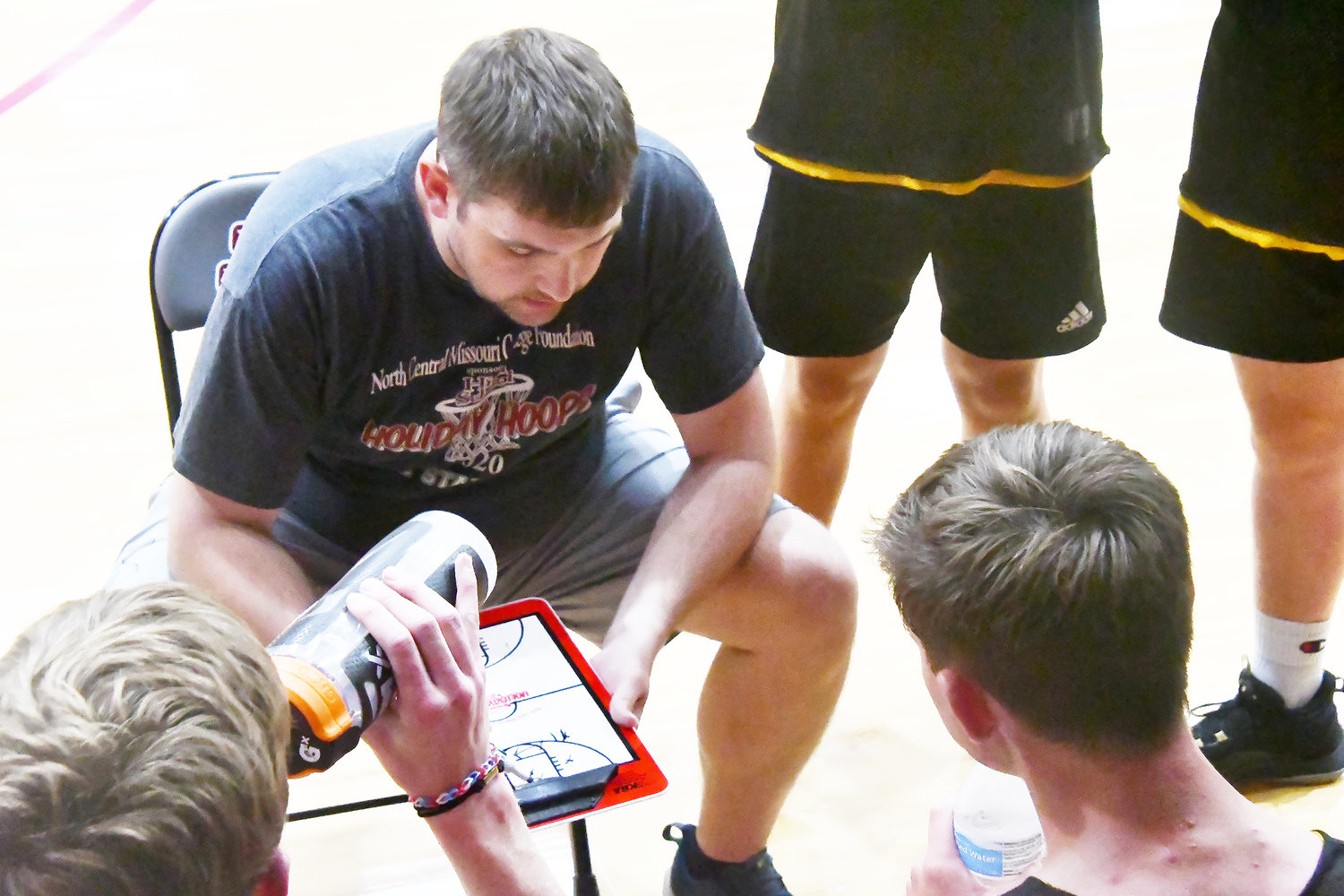 Higbee head boys' basketball coach Tanner Burton draws up a play during a timeout.