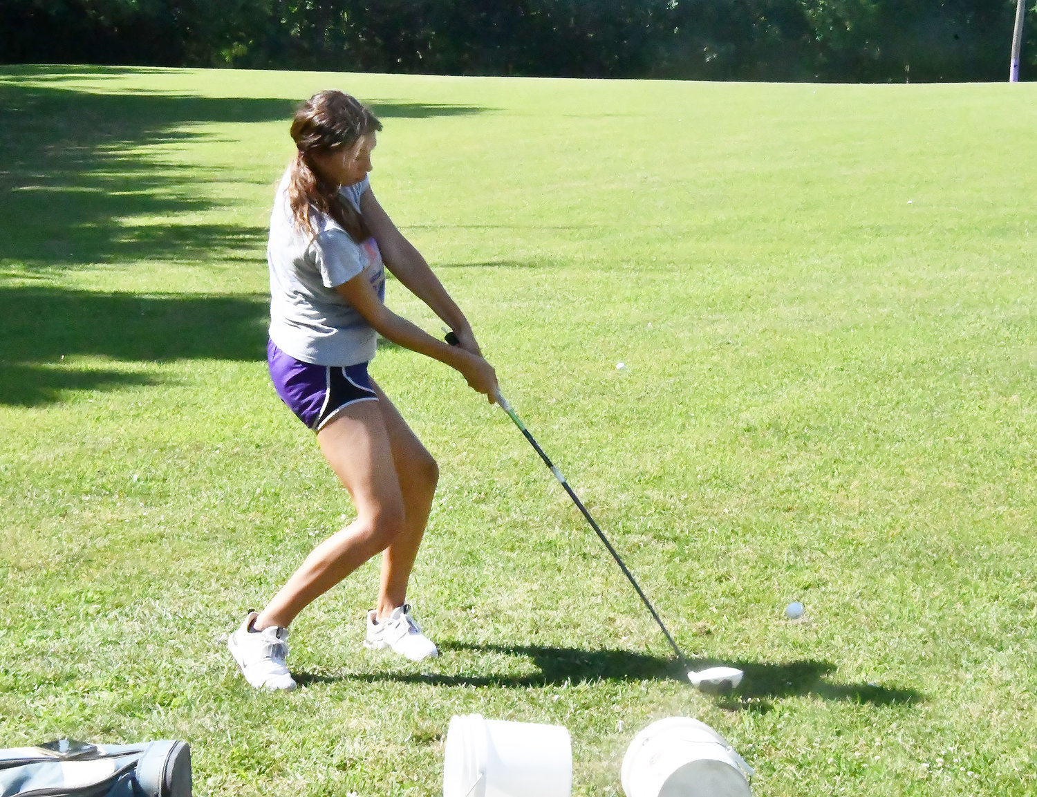 Cairo's Journey Sander hits an iron shot during Tuesday's clinic at Travis's Driving Range.