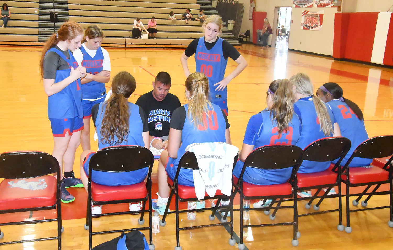 Moberly head girls' basketball coach Tony Vestal talks to his team during a timeout while Haley Baker, Elizabeth Reisenauer and Katelyn Bailey look on.