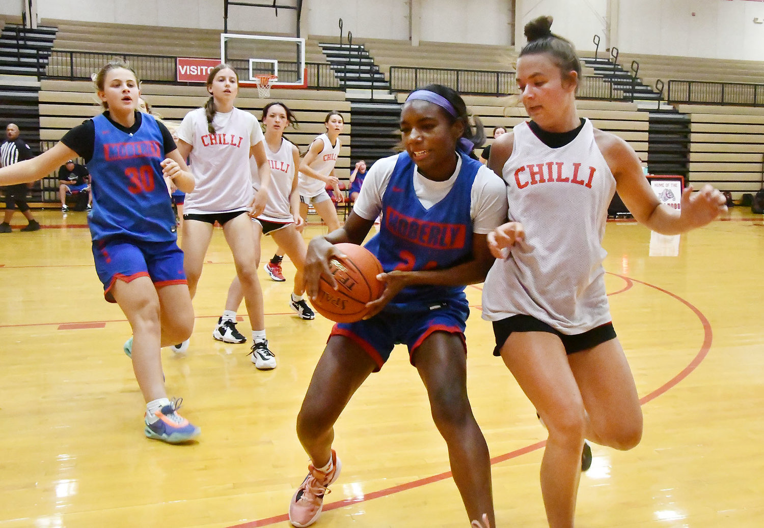 Moberly's Anyja Hayes grabs a rebound near the boundary during a scrimmage against Chillicothe. The Spartans earned a double-digit win.